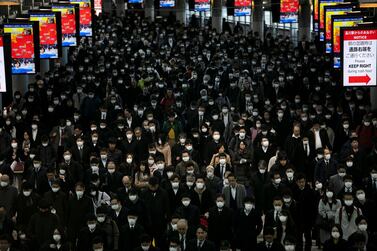 A large crowd of mask-wearing commuters walk through Shinagawa Station in Tokyo earlier this month. AP Photo