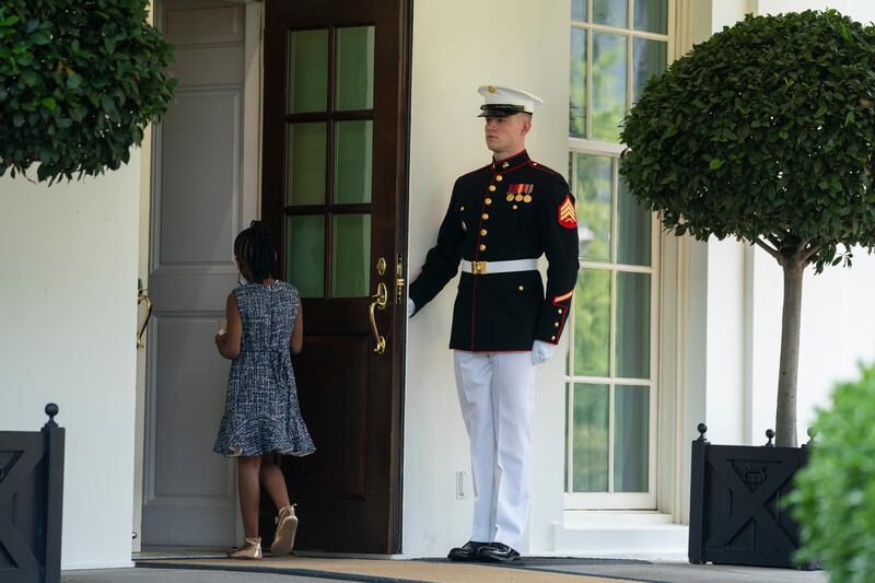 A US Marine holds the door as Gianna Floyd, the daughter of George Floyd, walks into the White House on May 25. Floyd was murdered by Minneapolis police officer Derek Chauvin the year before. AP