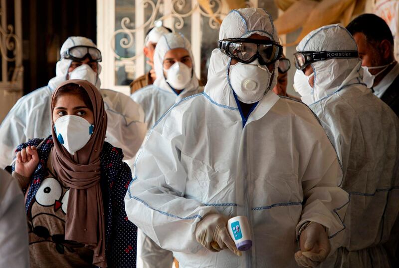 A medical team checks on travellers at the Shalamjah border crossing, some 15 kms southeast of the city of Basra, upon their return from Iran on February 21, 2020. Iran reported two more deaths among 13 new cases of coronavirus in the Islamic republic, bringing the total number of deaths to four and infections to 18. Following the announcement, Iraq clamped down on travel to and from the Islamic republic. The health ministry in Baghdad said people from Iran had been barred from entering Iraq "until further notice". / AFP / Hussein FALEH
