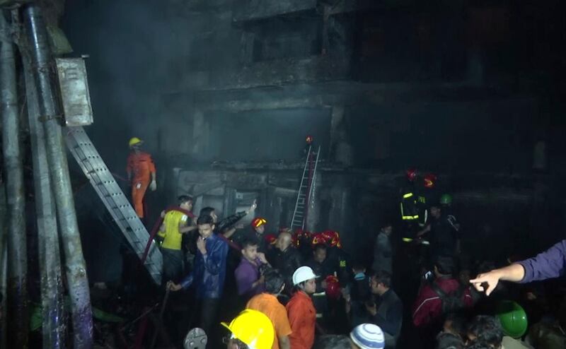 Firefighters and local people gather near smoldering buildings in Dhaka, Bangladesh. AP Photo