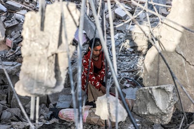 A girl salvages items from the rubble of a collapsed building in Rafah in the southern Gaza Strip. AFP