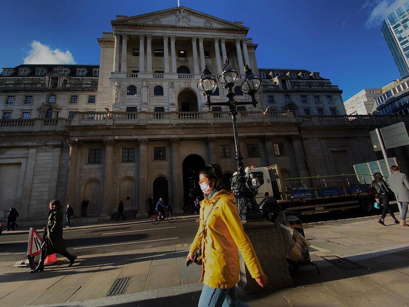 A pedestrian, wearing a protective face mask, walks past the Bank of England in the City of London on March 11, 2020, as Britain braces itself for an increase in cases of the novel coronavirus COVID-19. The Bank of England slashed its interest rate to a record low 0.25 percent on Wednesday as part of coordinated emergency action with the UK government to combat the economic fallout from the coronavirus outbreak. / AFP / DANIEL LEAL-OLIVAS
