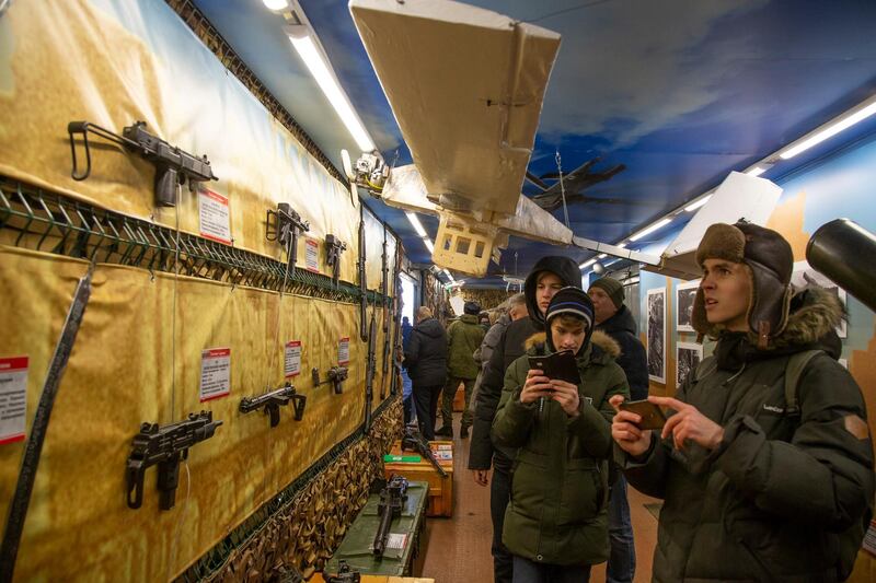 Visitors look at weapons and drones on display. AP Photo