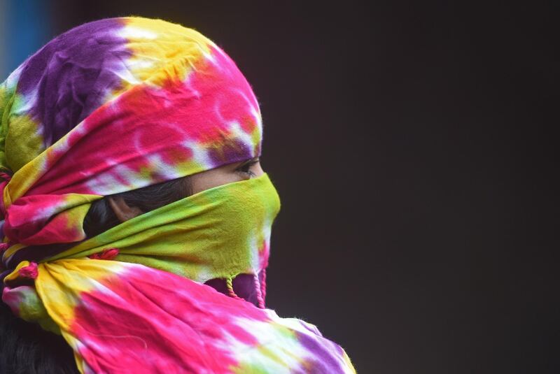 A woman with her face covered with scarf waits for her turn to get screened for the coronavirus, at a residential society in Mumbai, India. AFP