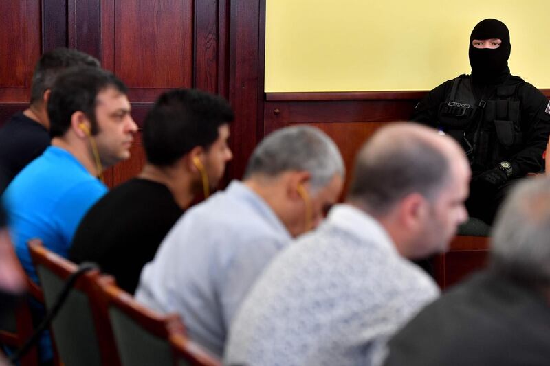 A policeman stands guard as defendants listen to the final verdict in their trial for the gruesome deaths of 71 migrants who suffocated in a lorry nearly four years ago on June 20, 2019 at a court in Szeged, Hungary.  The victims, 59 men, eight women and four children, including a baby, came from Syria, Iraq, and Afghanistan, joining hundreds of thousands like them trying to reach Germany in 2015.  / AFP / ATTILA KISBENEDEK
