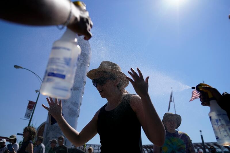 Fans gets spay with water after events were postponed due to high heat at the U.S. Olympic Track and Field Trials Sunday, June 27, 2021, in Eugene, Ore. (AP Photo/Ashley Landis)