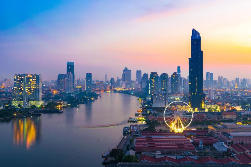 Bangkok city during twilight time, travel and shopping place, Chaophraya River, Condominiums & Hotels, Landmark wheel. Getty Images