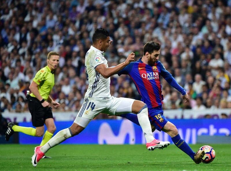 Real Madrid’s Casemiro, left, vies with Messi for possession. Gerard Julien / AFP