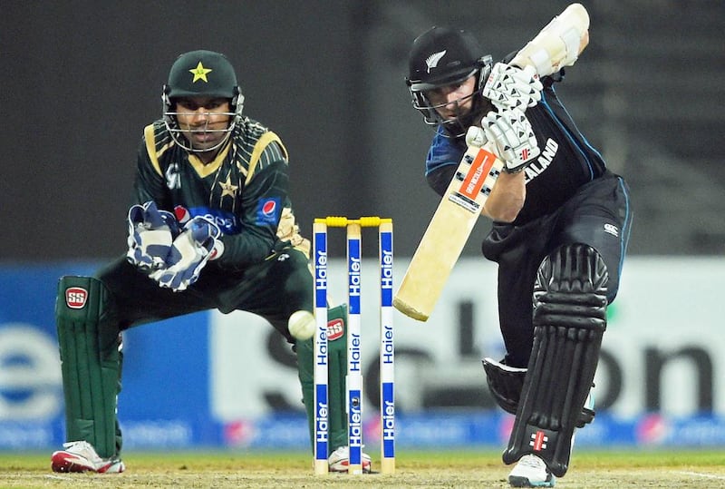 New Zealand captain Kane Williamson, right, plays a shot as Pakistani wicketkeeper Sarfraz Ahmed looks on during the second one-day international cricket match at the Sharjah cricket stadium on December 12, 2014. Aamir Qureshi / AFP