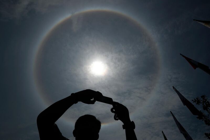 A halo around the sun is seen as a spectator takes a picture of the podium at the 2018 Asian Games Triathlon in Indonesia.  Reuters