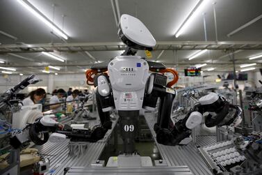 A humanoid robot works side by side with employees in the assembly line at a factory of Glory, a manufacturer of automatic change dispensers, in Kazo, north of Tokyo, Japan, in 2015. Reuters