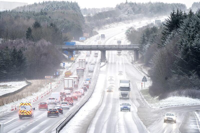 Motorists drive through sleet and snow on the M8 motorway near Bathgate, in West Lothian, Scotland. PA
