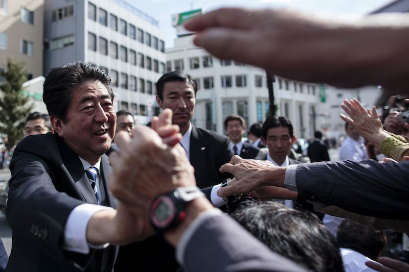 This file photo taken on October 18, 2017 shows Japan's Prime Minister and ruling Liberal Democratic Party (LDP) president Shinzo Abe (L) greeting his supporters during an election campaign appearance in Saitama. AFP