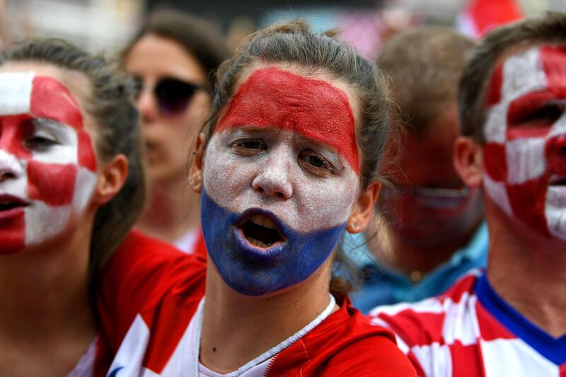 A woman cheers as people gather for a "heroes' welcome" in tribute to Croatian national football team, after reaching the final at the Russia 2018 World Cup, at the Bana Jelacica Square in Zagreb, on July 16, 2018.  / AFP / Dimitar DILKOFF
