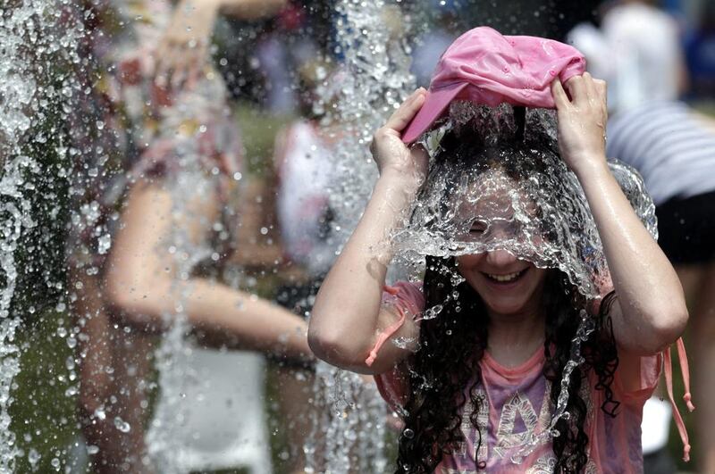 A girl dumps a hat full of water over herself at the Australian Open on Wednesday.