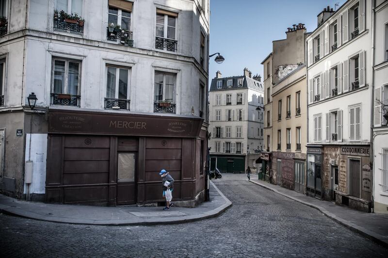 A man wearing a face mask walks on a deserted street transformed into a movie set, in Paris, France. EPA