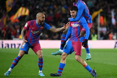 Barcelona's Spanish midfielder Pedri celebrates scoring the opening goal with Barcelona's French forward Ousmane Dembele (TOP) and Barcelona's Brazilian defender Dani Alves (L) during the Spanish League football match between FC Barcelona and Sevilla FC at the Camp Nou stadium in Barcelona on April 3, 2022.  (Photo by LLUIS GENE  /  AFP)