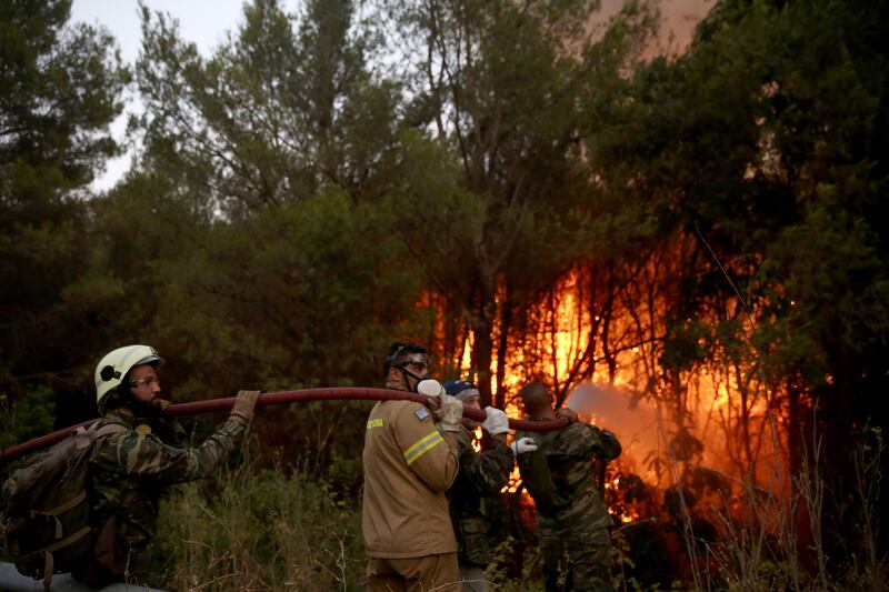 Firemen battle to extinguish a wildfire in Varybobi, Greece.