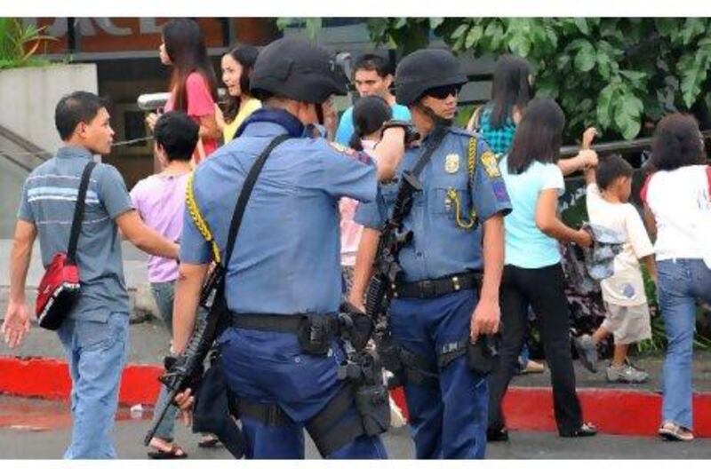 Heavily armed police officers secure a shopping centre in Manila yesterday following warnings of possible terror attacks.