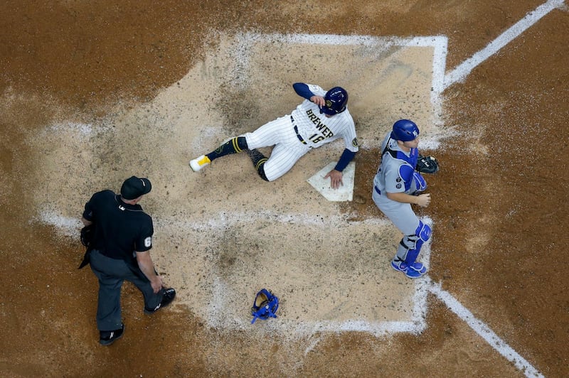 Milwaukee Brewers' Kolten Wong scores from third on a ball hit by Luke Maile during the eighth inning of the MLB game against the Los Angeles Dodgers at Miller Park on Friday, April 30. Brewers won the match 3-1. AP
