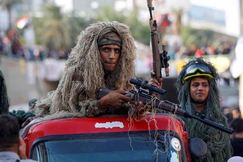 An Iraqi demonstrator wears sniper clothes, pretending to be a sniper during ongoing anti-government protests, in Baghdad. Reuters