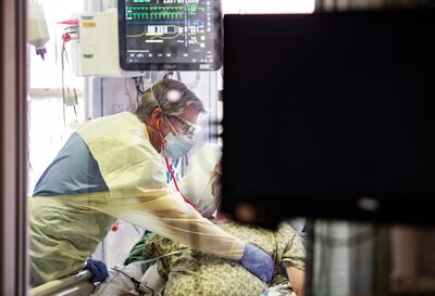 Dr William Dittrich looks over a Covid-19 patient in the intensive care unit at St Luke's Boise Medical Centre in Boise, Idaho. AP
