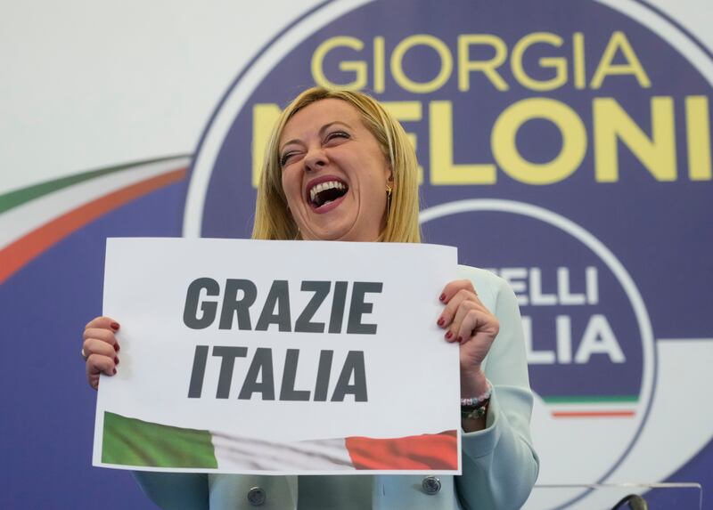 Far-right party Brothers of Italy's leader Giorgia Meloni shows a placard reading in Italian, 'Thank you Italy' at her party's electoral headquarters in Rome. AP
