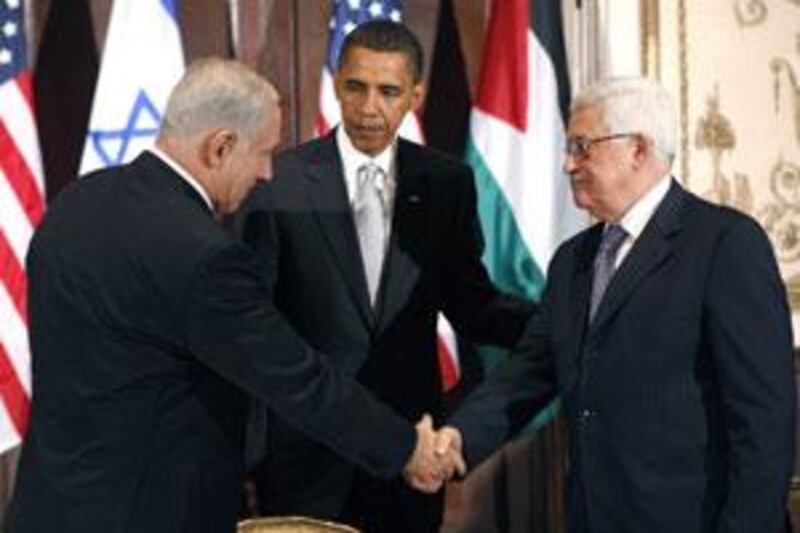 Barack Obama watches Benjamin Netanyahu, left, and Mahmoud Abbas, right, shake hands during a trilateral meeting in New York.