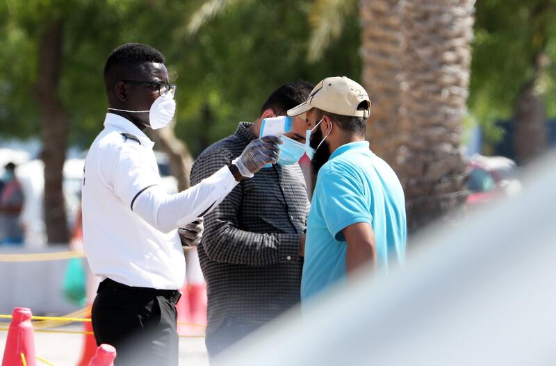 DUBAI, UNITED ARAB EMIRATES , May 5 – 2020 :- Security guard checking the temperature of the visitor at the Al Awir fruit & vegetable market in Dubai. UAE government ease the coronavirus restriction for the residents around the country. (Pawan Singh / The National) For News/Standalone/Online/Stock