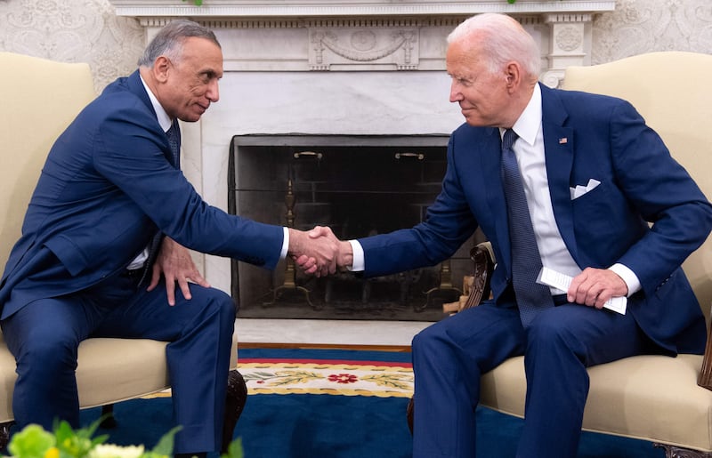 US President Joe Biden shakes hands with Iraqi Prime Minister Mustafa Al Kadhimi at the Oval Office at the White House in Washington.