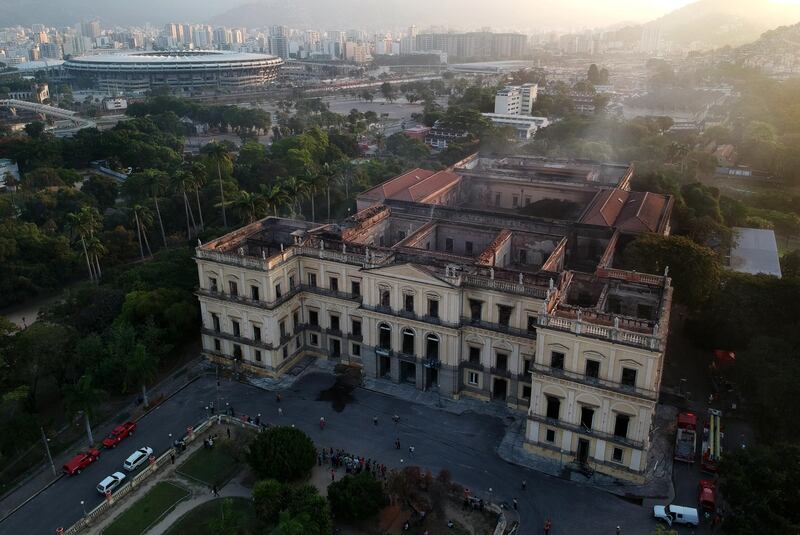 Drone view of Rio de Janeiro's treasured National Museum, one of Brazil's oldest, with the Maracana stadium in the background, on September 3, 2018, a day after a massive fire ripped through the building. - The majestic edifice stood engulfed in flames as plumes of smoke shot into the night sky, while firefighters battled to control the blaze that erupted around 2230 GMT. Five hours later they had managed to smother much of the inferno that had torn through hundreds of rooms, but were still working to extinguish it completely, according to an AFP photographer at the scene. (Photo by Mauro Pimentel / AFP)