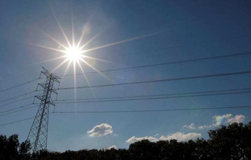 FILE PHOTO: The sun shines over a high tension power line in an industrial area of Sydney May 4, 2009. REUTERS/Tim Wimborne/File Photo