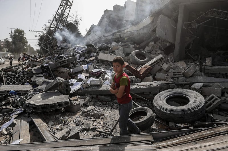 A Palestinian boy stands amidst the rubble. AFP