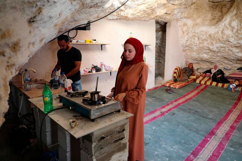 Ahmed Amarneh and his wife prepare coffee in the kitchen of his cave home. AFP