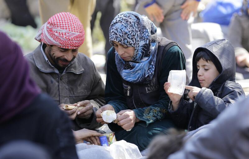 Syrian civilians evacuated from rebel-held areas in Eastern Ghouta gather at a school in the regime-controlled Adra district, on the north-eastern outskirts of the capital Damascus, on March 16, 2018. Louia Beshara / AFP