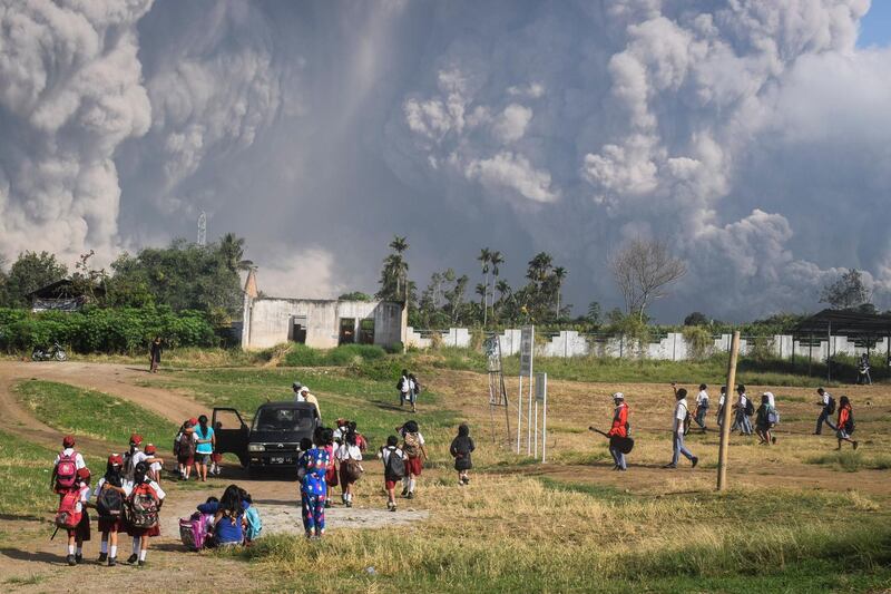 Indonesian students walk as Mount Sinabung erupts in Karo, North Sumatra, Indonesia. Sarianto Ojo Sembiring / AFP