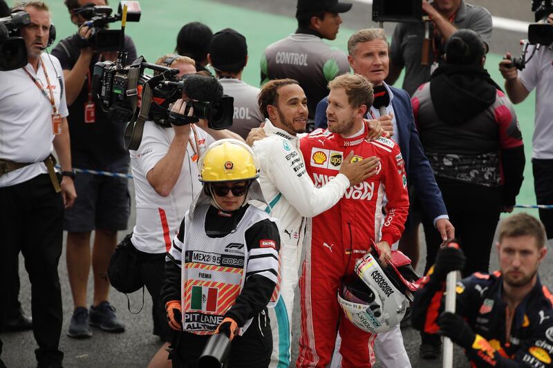 Lewis Hamilton is congratulated by Sebastian Vettel. EPA