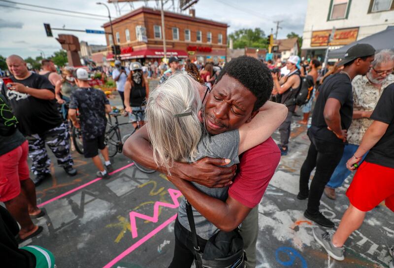 Kathy Boyum is hugged by Jeffrey Edwards during a reconciliation revival, part of an event to mark Juneteenth in Minneapolis, Minnesota, US. Reuters