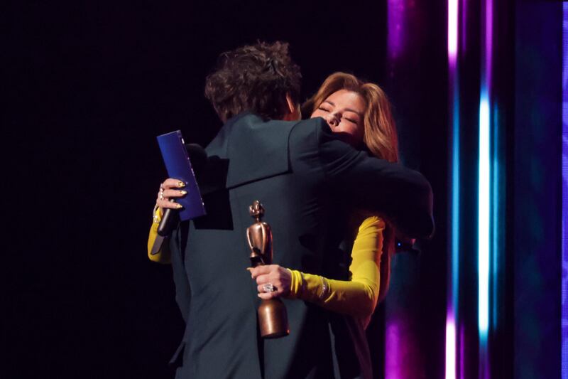 Harry Styles, left, and Shania Twain hug on stage. AP