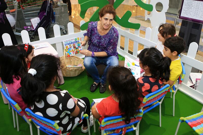 DUBAI, UAE. April 24, 2014 - Leonara Pacini reads a story to a group of children at a children's carnival hosted by the Dubai Foundation for Women and Children  to raise awareness about child abuse at Mirdif City Centre  in Dubai, April 24, 2014. (Photos by: Sarah Dea/TheNational, Story by: Nouf Bakhsh, News)
