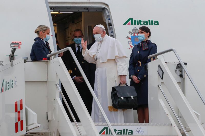 Pope Francis waves as he boards the plane for his visit to Iraq, at Leonardo da Vinci-Fiumicino Airport in Rome, Italy, March 5, 2021. REUTERS/Remo Casilli