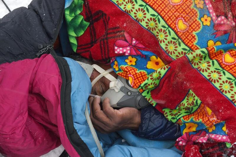 Banja, a porter working for a trekking company holds on to a gas mask after he was injured by snow and debris from an avalanche that flattened parts of the base camp.