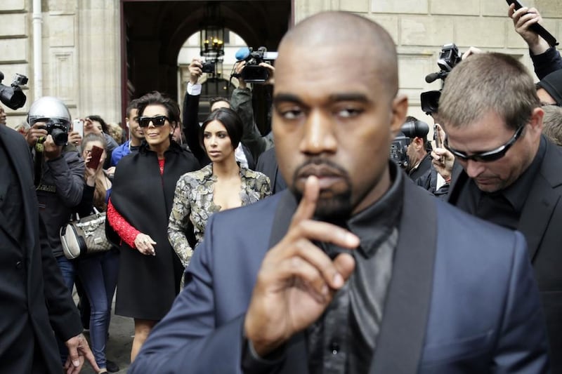 Kim Kardashian, centre, pushes a stroller next to her partner Kanye West, front, and her mother Kris Jenner, second to left, as they leave their hotel on May 23, 2014 in Paris. Kenzo Tribouillard / AFP photo