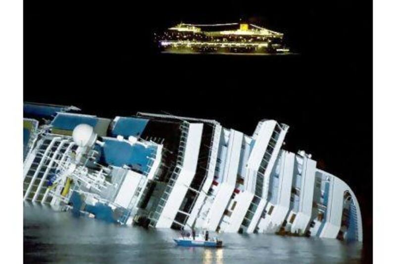 The cruise ship Costa Serena passes offshore as its sister ship Costa Concordia lies on its side off the Tuscan island of Giglio. The Italian Ambassador says that a cartoon depiction of the accident was in poor taste. Angela Carconi / AP