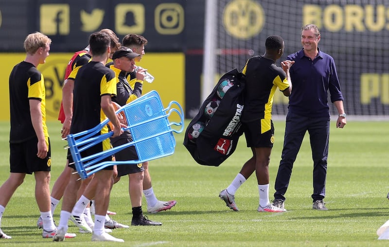 Dortmund's 15-year-old player Youssoufa Moukoko, second right, talks to Dortmund's sports director Michael Zorc during the team's first pre-season training session. EPA