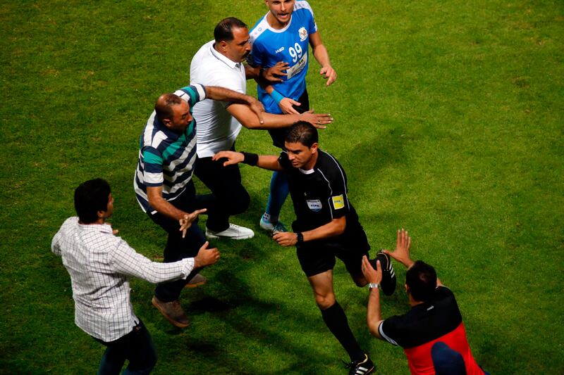 Egyptian referee Ibrahim Noor El Din, centre, is on the run following a clash with players of Jordanian side Al Faisaly at the end of the Arab Club Championship final against Tunisian side Esperance de Tunis in Alexandria, Egypt, late on Sunday night. Ibrahim Ezzat / AFP