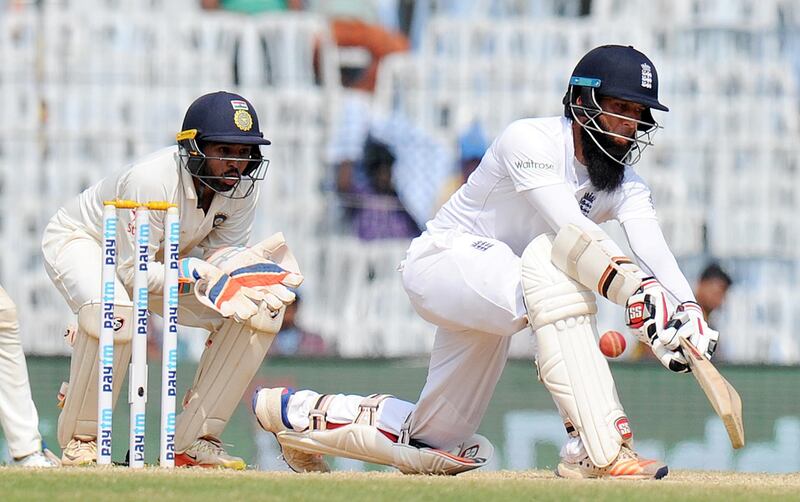 England's Moeen Ali plays a shot as India's Parthiv Patel looks on during the fifth day of the fifth and final Test cricket match between India and England at the M.A. Chidambaram Stadium in Chennai on December 20, 2016. (Photo by ARUN SANKAR / AFP) / ----IMAGE RESTRICTED TO EDITORIAL USE - STRICTLY NO COMMERCIAL USE----- / GETTYOUT