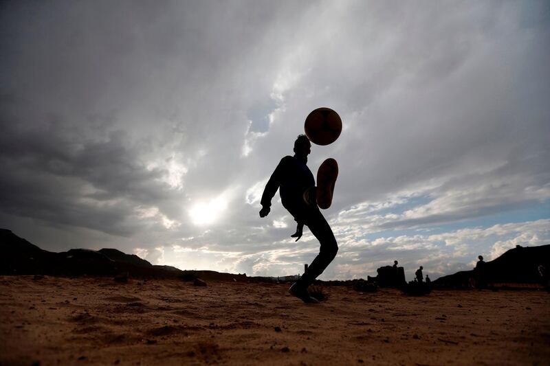 A Yemeni boy kicks up a football in the air during a match among friends and neighbours in the capital Sanaa. Mohammed Huwais / AFP