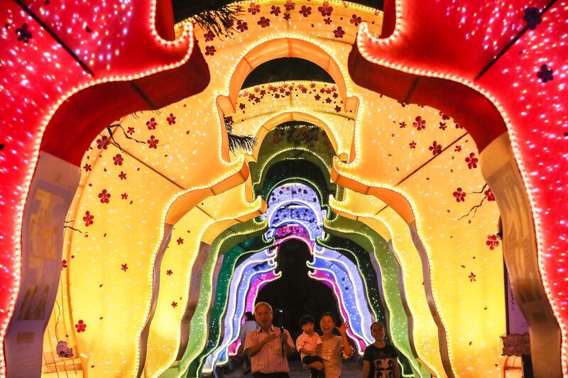 A family passes under a Buddha gate decoration at the Dong Zen temple in Jenjarom, Malaysia. EPA