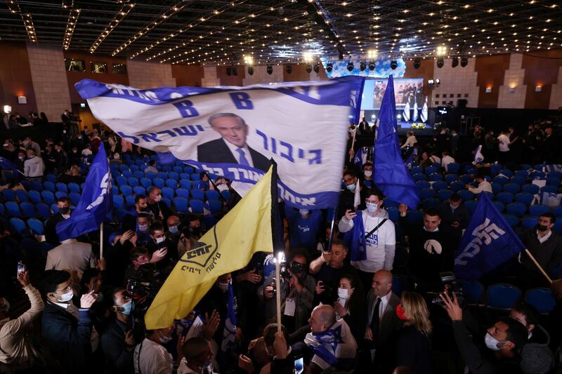 Supporters of Israeli Prime Minister Benjamin Netanyahu wave a flag depicting him as they react following the results of the exit polls in Israel's general elections at Netanyahu's Likud party headquarters in Jerusalem. Reuters